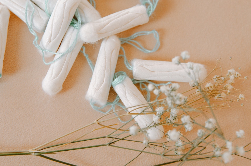 tampons and white flowers on tan background